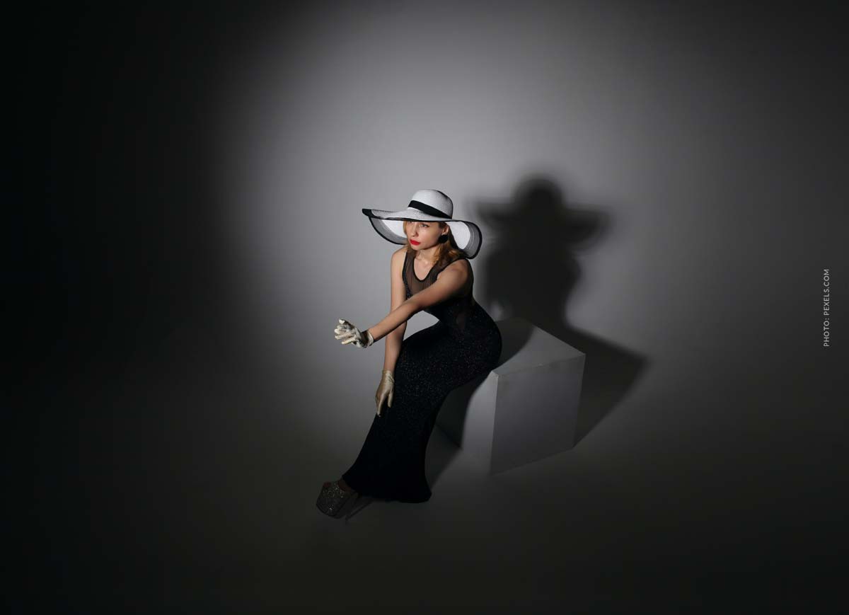 Lanvin: fashion brand, designers, collaborations and shows lanvin-designer-fashion-brand-dark-room-with-woman-in-black-dress-and-white-hat-in-the-middle